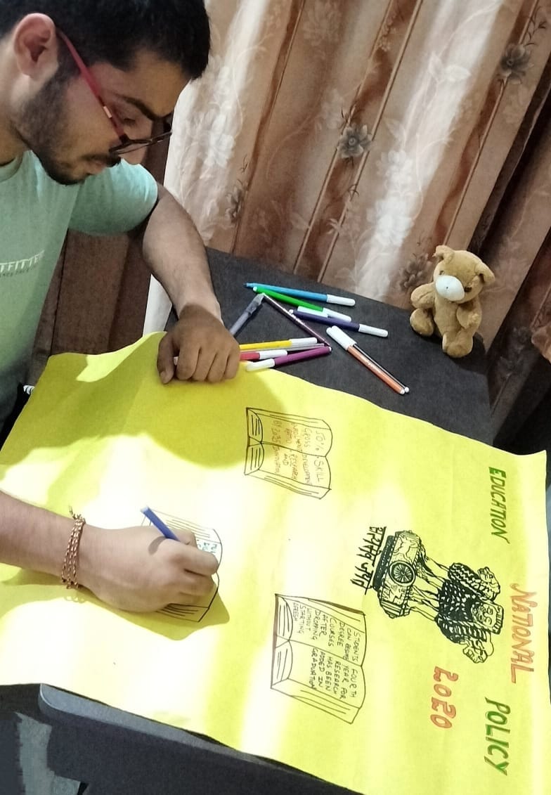 राष्ट्रीय शिक्षा नीति-2020 के क्रियान्वन एवं प्रगति से संबंधित तैयार किए गए चार्ट-पोस्टर तैयार करता भौतिकी एवं खगोल विज्ञान विभाग का छात्र।